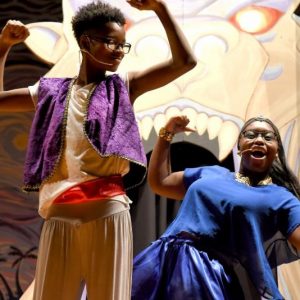 Two kids dressed as Aladdin and Genie performing