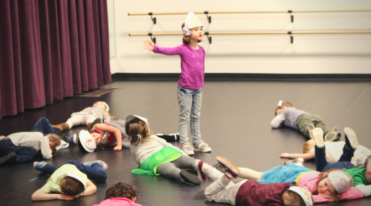 Kids laying on floor and one girl standing