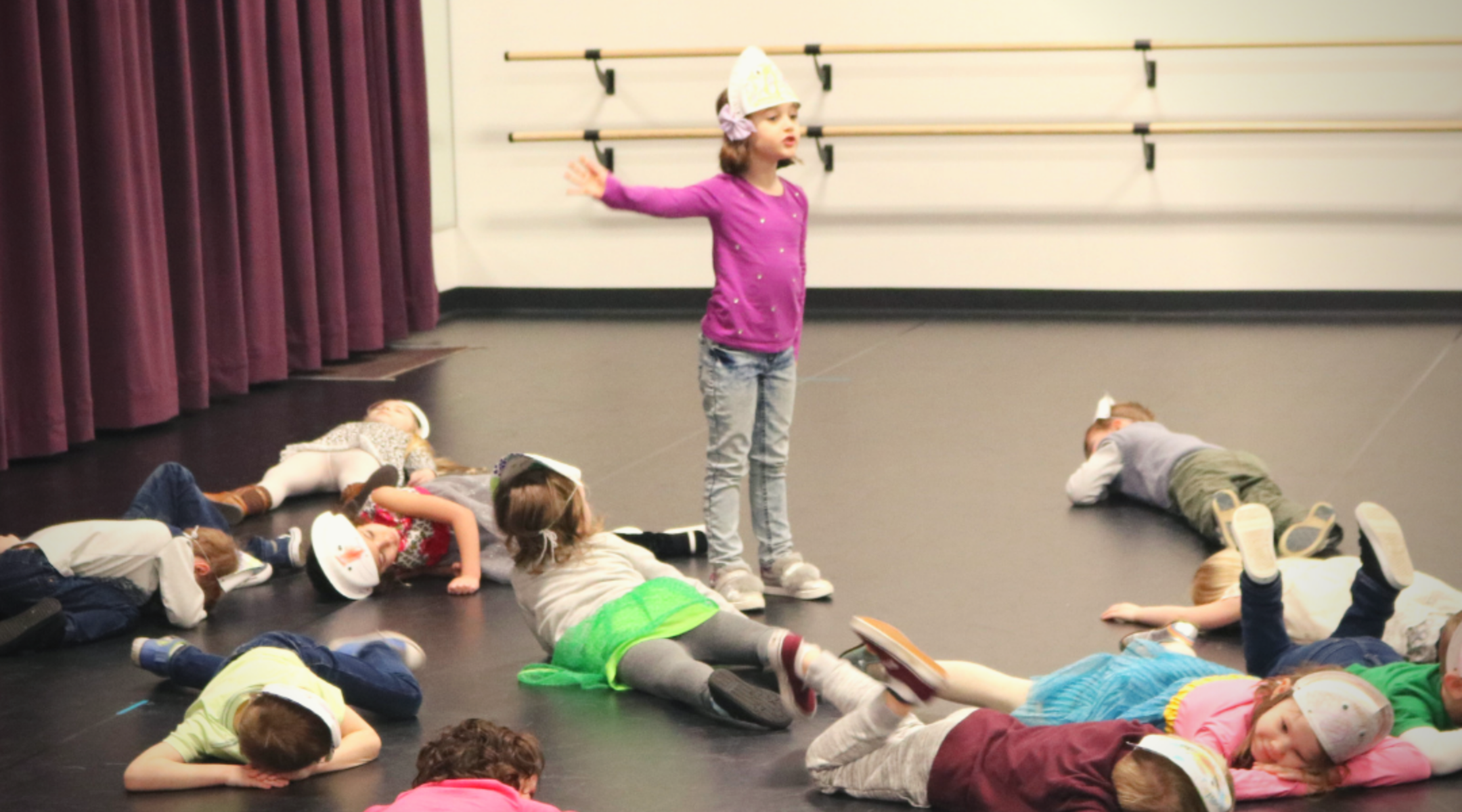 Kids laying on floor and one girl standing