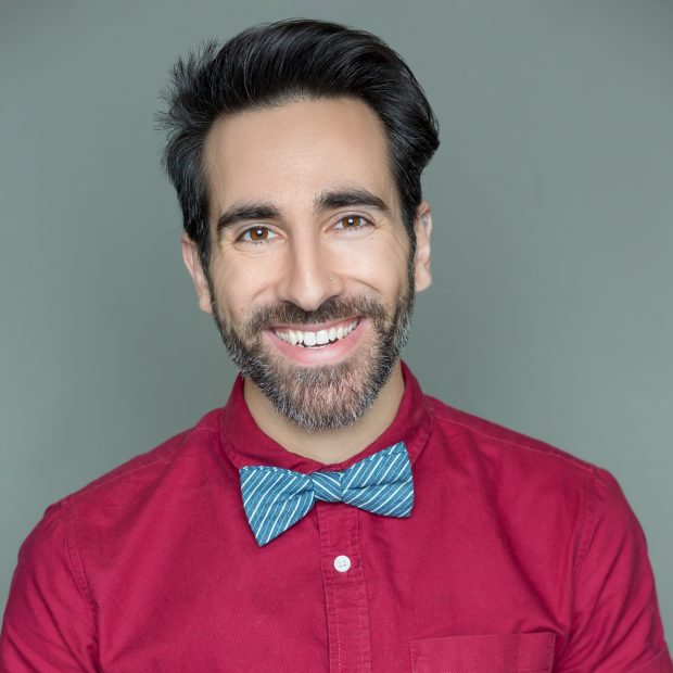 man in red shirt and bowtie smiling