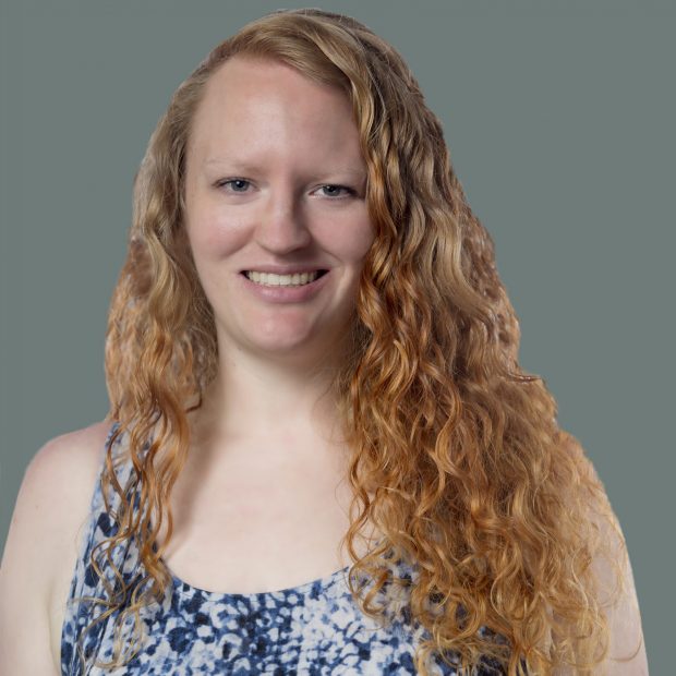 Woman smiling with curly hair and navy dress