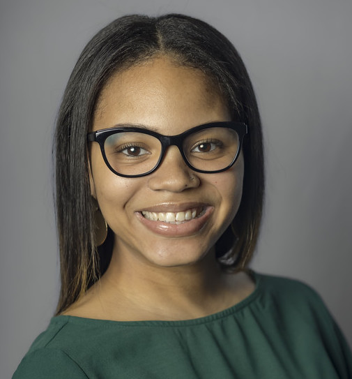 woman in glasses wearing dark green shirt