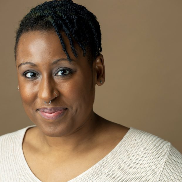 Woman in white shirt with neutral background smiling