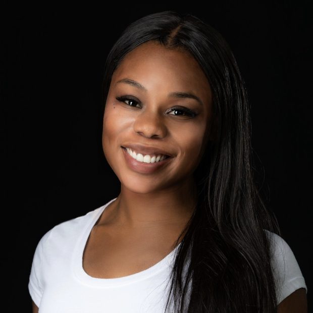 Woman with long black hair and a white shirt with a black background