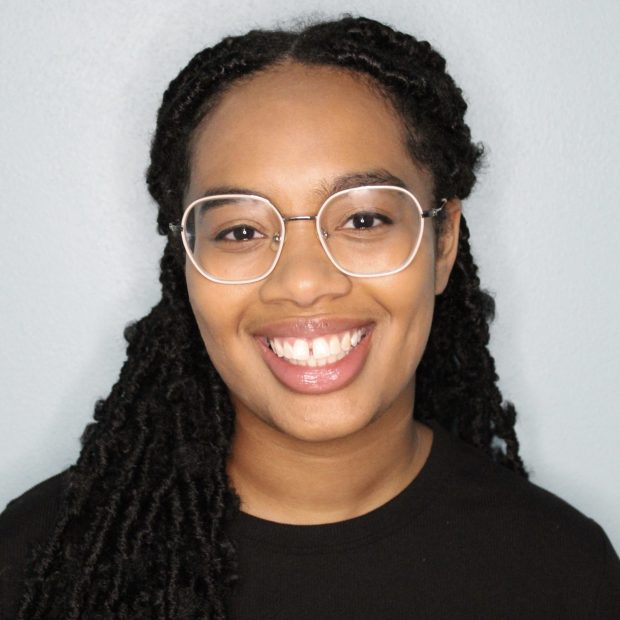 Woman with glasses in a black shirt with a white background