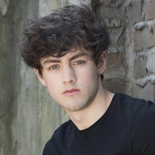Young man with black shirt and brick background