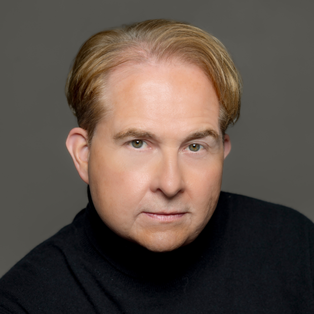 Man in dark velvet suit with green background