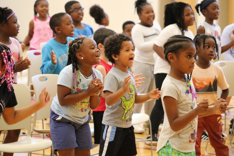 Group of kids clapping and singing