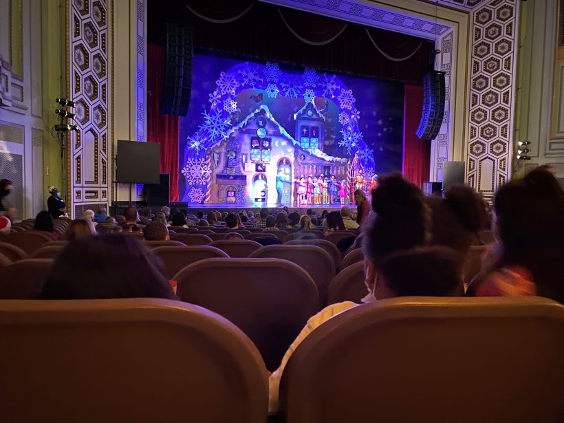 young girl sitting in theatre seat