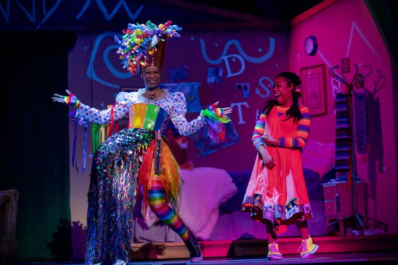 woman in rainbow costume and woman in orange dress