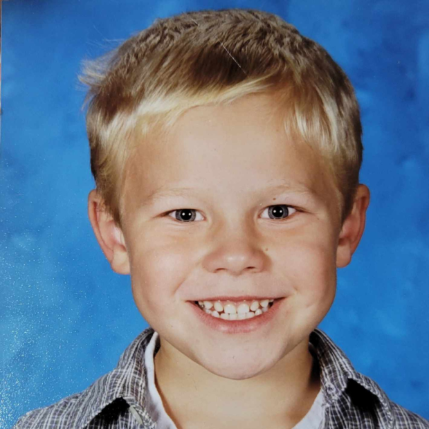 child with blond hair and blue background